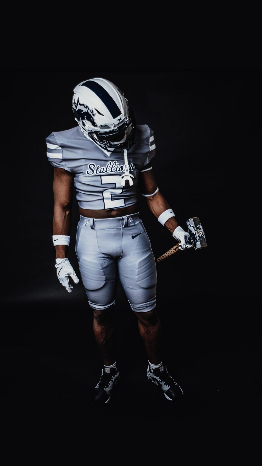 NAU football player holding a sledgehammer